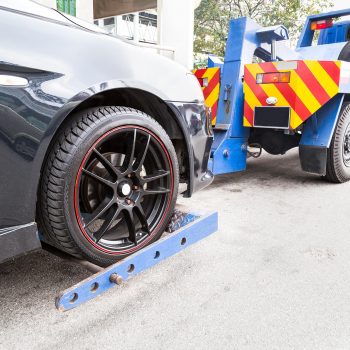 tow-truck-towing-a-broken-down-car-on-the-street-P46CHJA.jpg